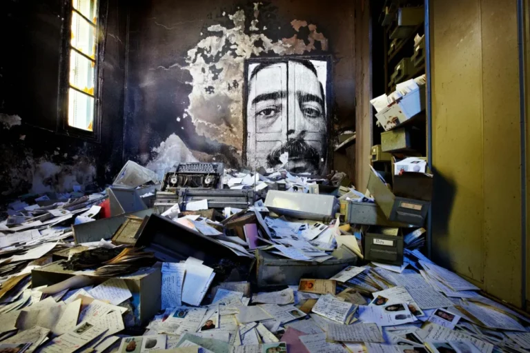 Retrato monumental en blanco y negro de un rostro masculino instalado sobre una pared interior en ruinas, proyecto INSIDE-OUT: Autocrazy in Tunisia, 2011.