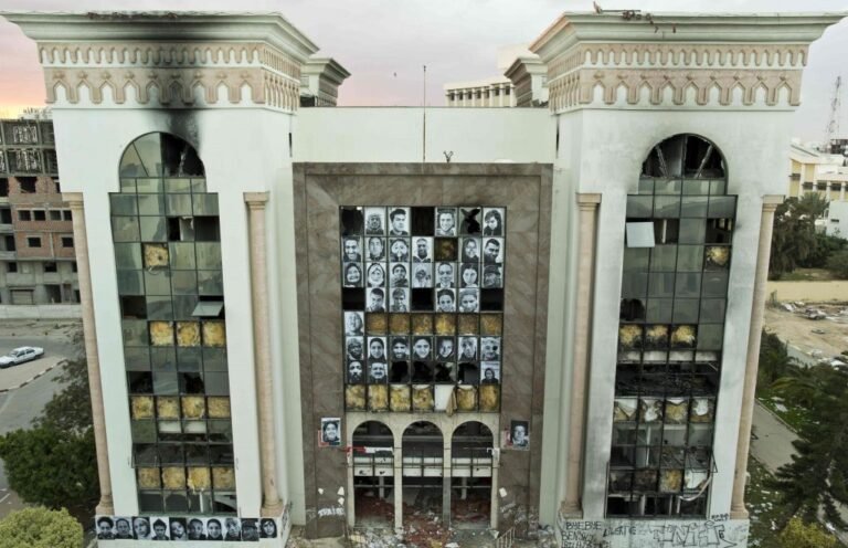 Fachada institucional dañada con múltiples retratos fotográficos en blanco y negro dispuestos en cuadrícula, proyecto INSIDE-OUT: Autocrazy in Tunisia.