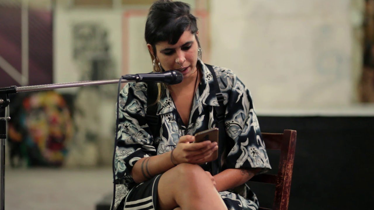 Patricia Heras recitando poesía, rostro joven con mirada intensa hacia adelante.
